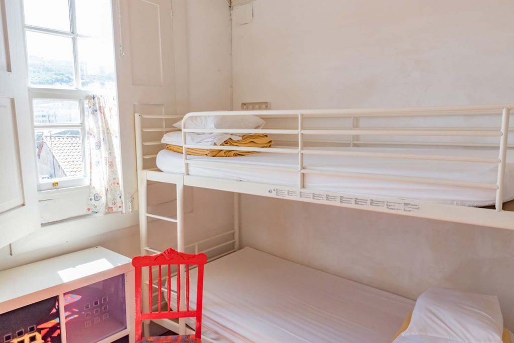 Ein Zimmer in einem Hostel mit Hochbett und Stuhl