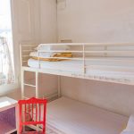Ein Zimmer in einem Hostel mit Hochbett und Stuhl