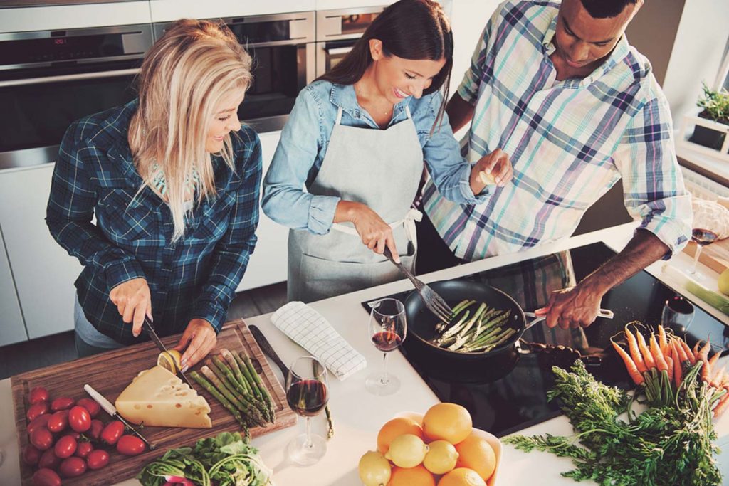 Drei Freunde kochen zusammen