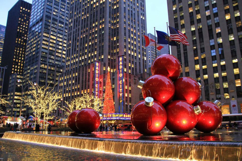 Große Weihnachtskugeln liegen auf einem Brunnen
