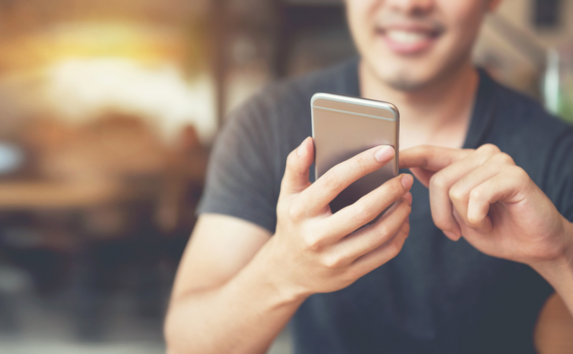 Junger Mann benutzt sein Smartphone