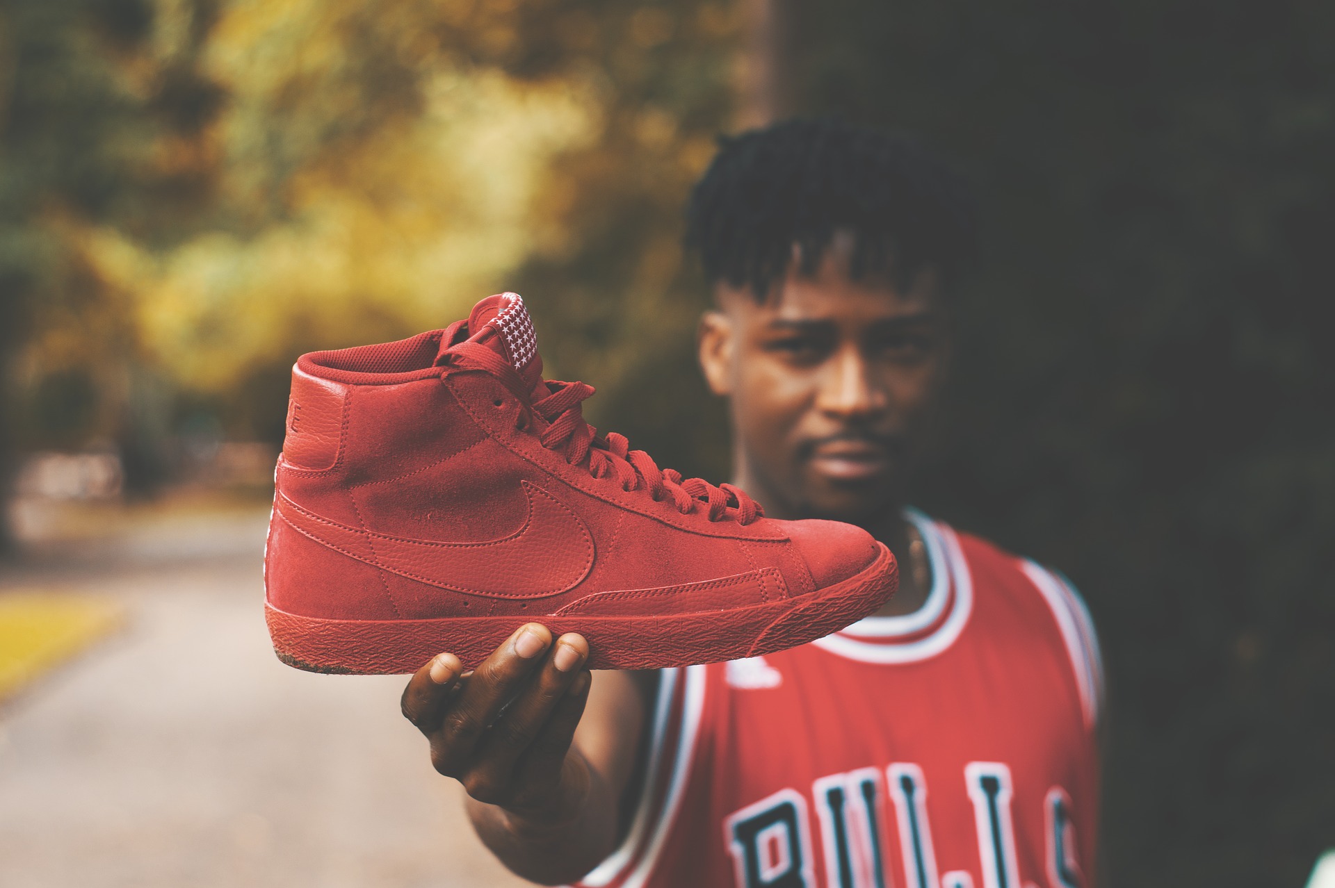 Mann hält roten Basketballschuh in die Kamera