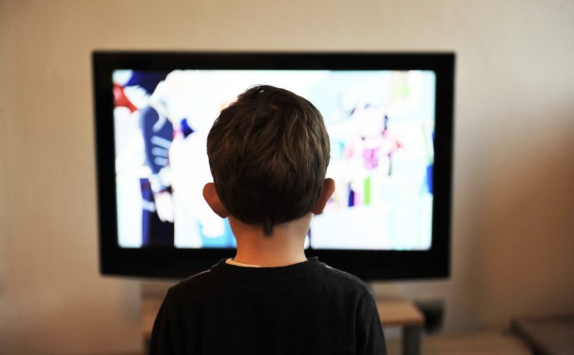 Kind vor dem laufenden Fernseher