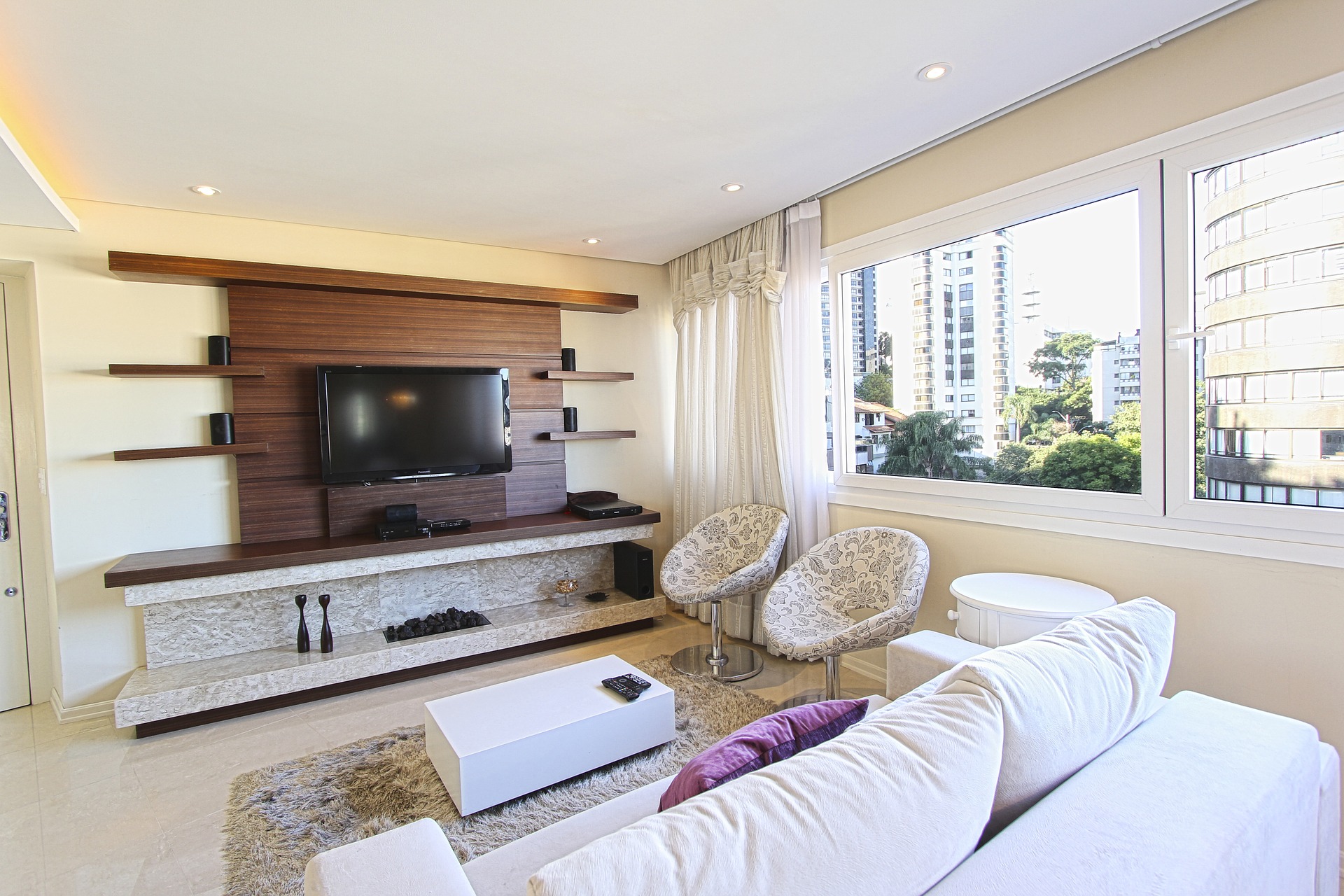 Helles Wohnzimmer mit Couch und Fernseher. 