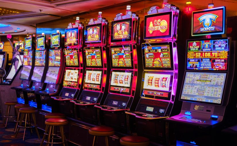 Acht Spielautomaten nebeneinander in einem Casino