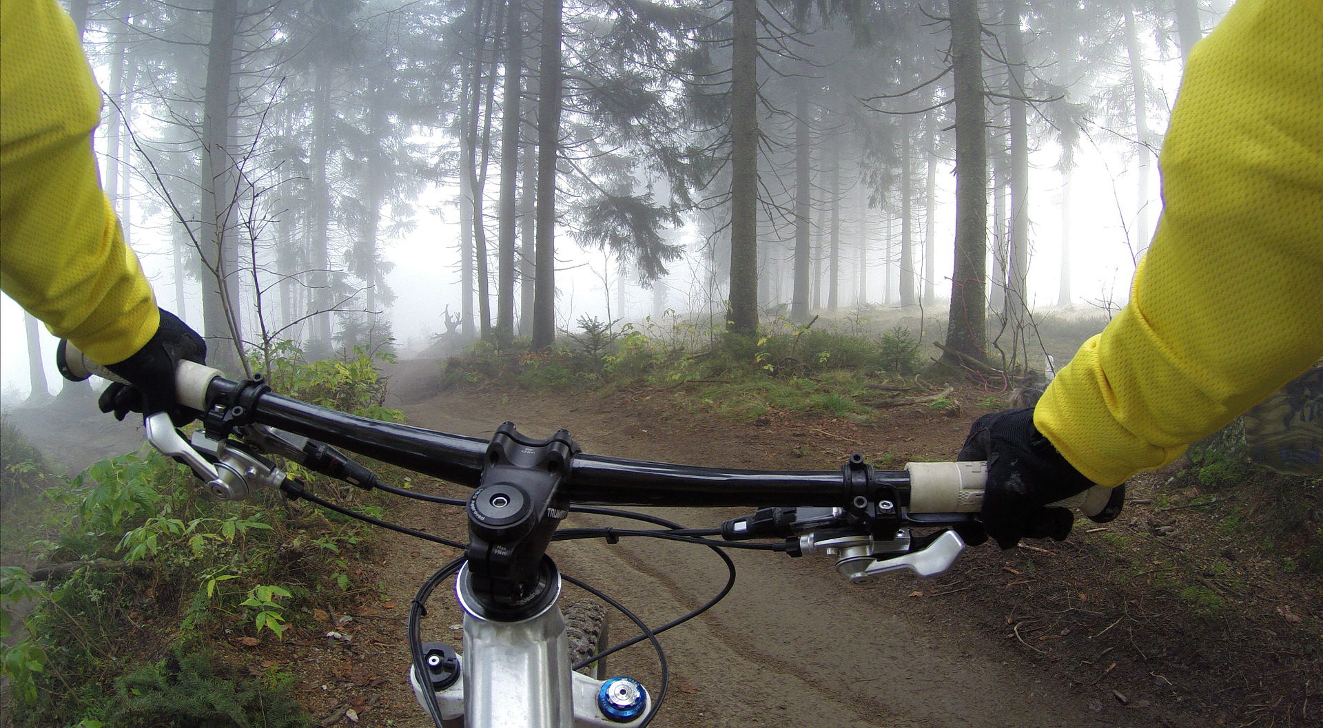 Mann fährt im Winter mit seinem Mountainbike durch den Wald.