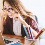 Junge Frau studiert am Laptop verfügbare Vertragsangebote